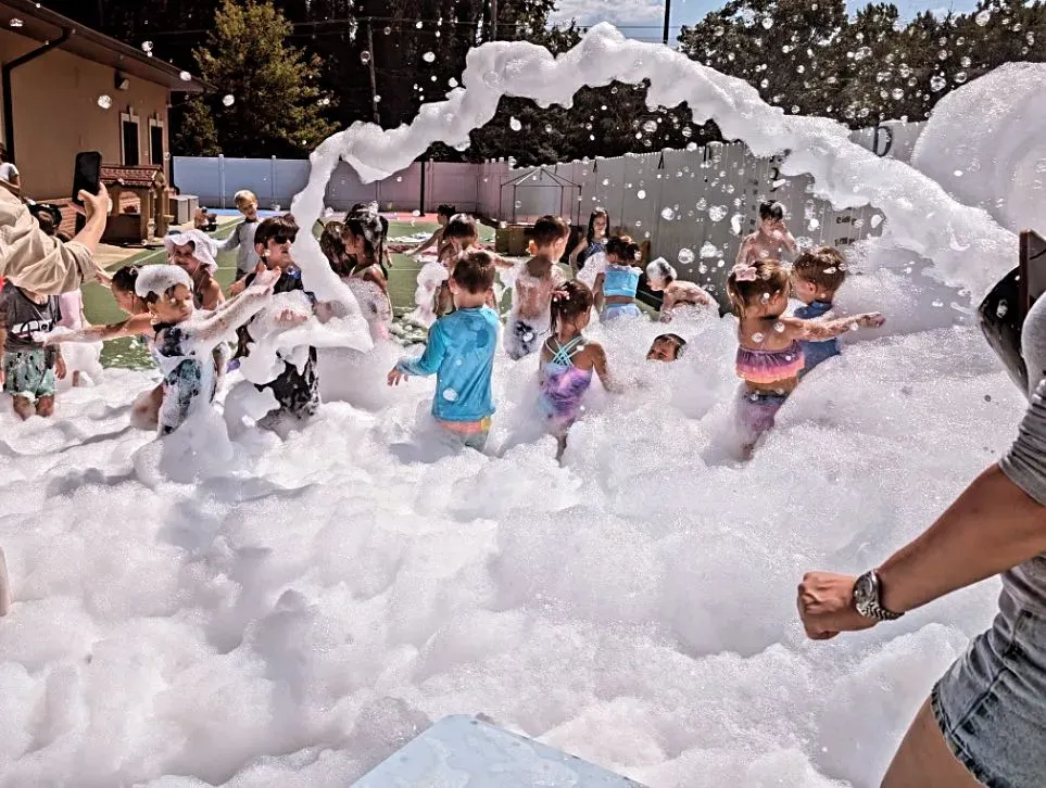 Party guests beneath an arc of foam